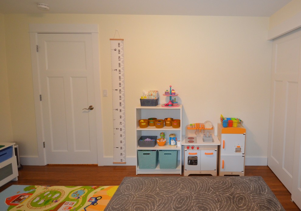 Inspiration pour une petite chambre d'enfant de 1 à 3 ans traditionnelle avec un mur beige, un sol en bois brun et un sol marron.