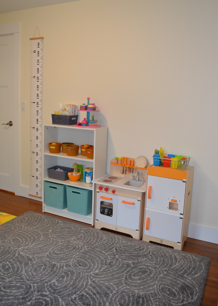 Idee per una piccola cameretta per bambini da 1 a 3 anni tradizionale con pareti beige, pavimento in legno massello medio e pavimento marrone