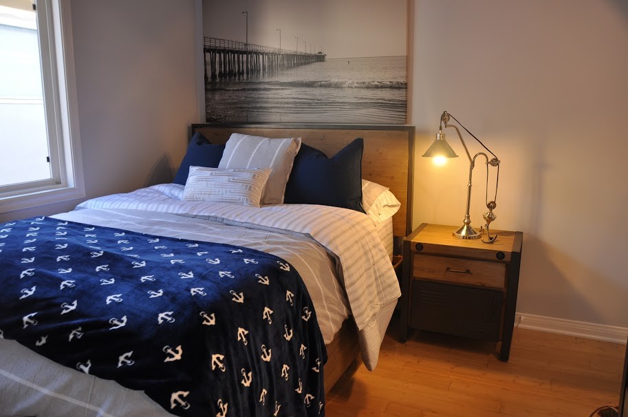 Foto på ett maritimt sovrum, med bambugolv och grå väggar