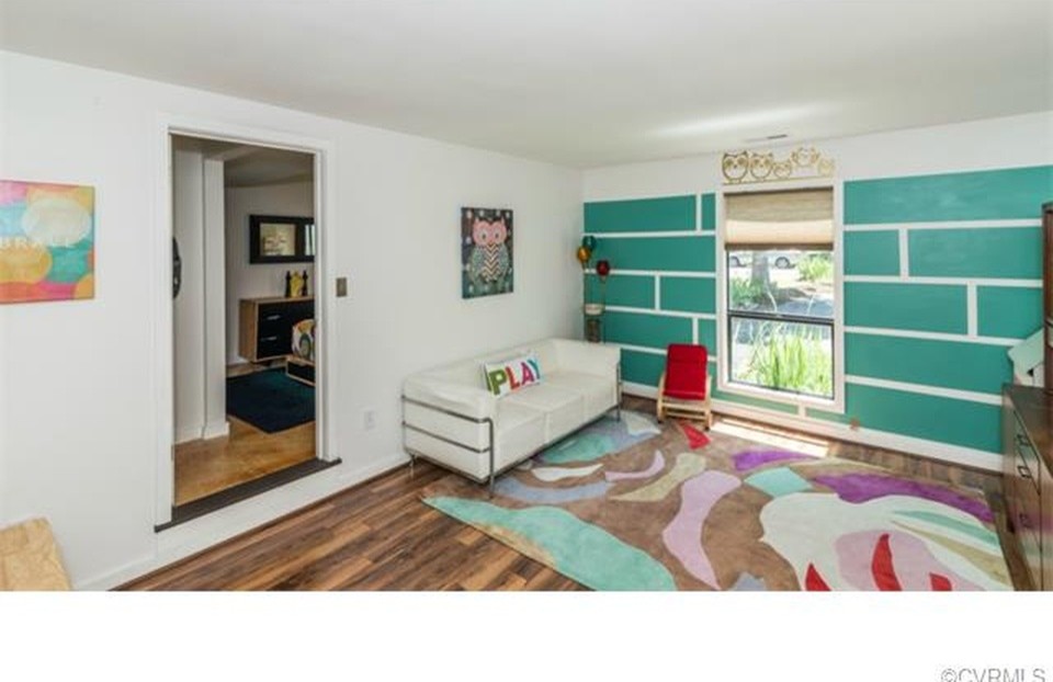 Idées déco pour une chambre d'enfant de 1 à 3 ans rétro de taille moyenne avec un mur multicolore et un sol en bois brun.