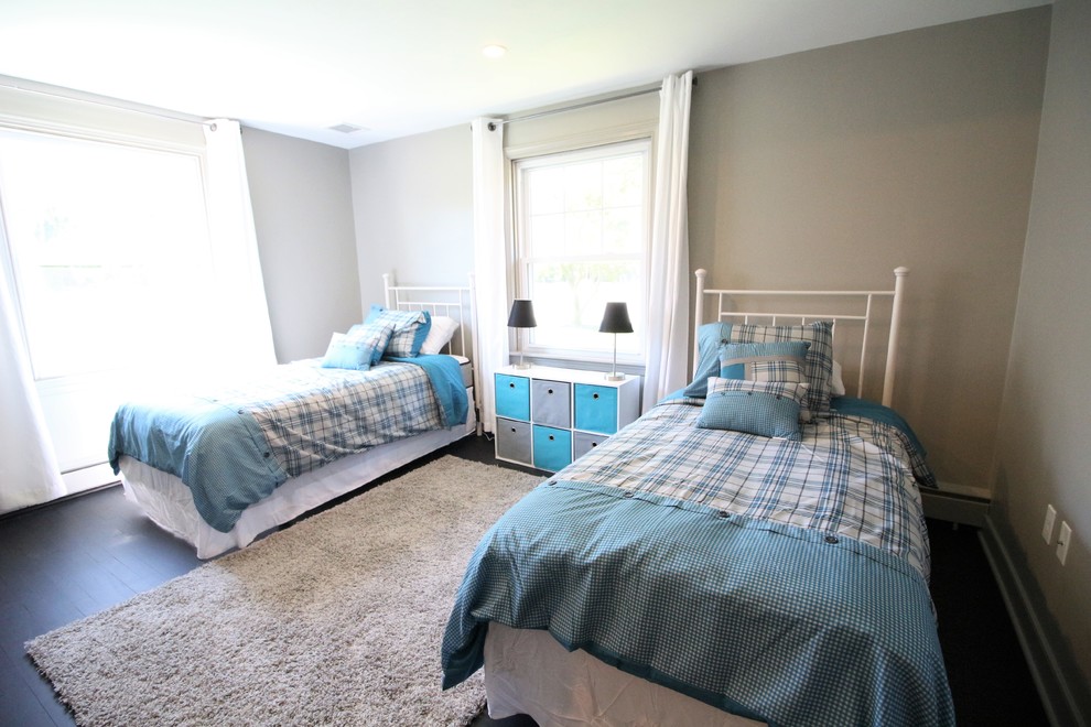 This is an example of a small traditional gender neutral kids' bedroom in Other with grey walls, dark hardwood flooring and black floors.