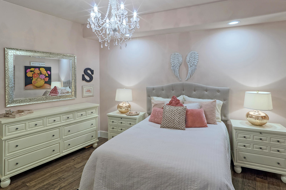 Exempel på ett mellanstort klassiskt barnrum kombinerat med sovrum, med rosa väggar och mörkt trägolv