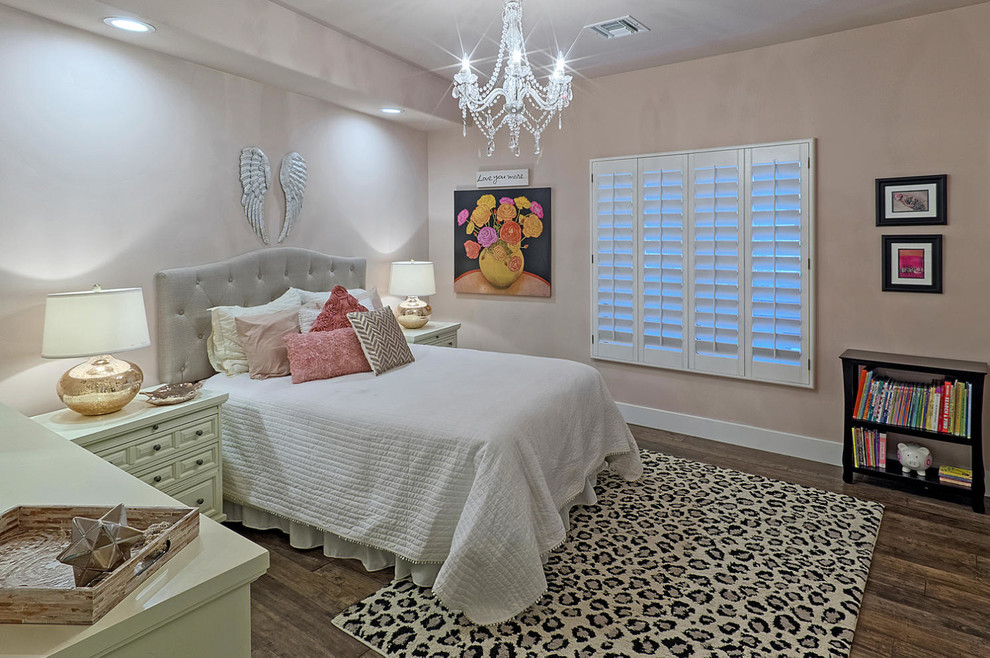 Inredning av ett klassiskt mellanstort barnrum kombinerat med sovrum, med rosa väggar och mörkt trägolv