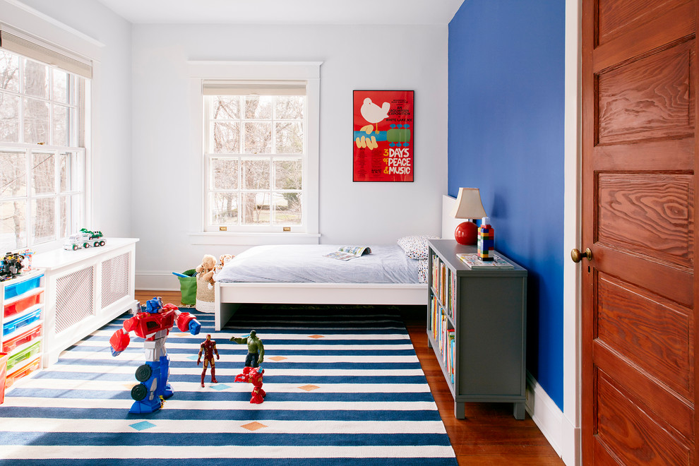 Klassisches Jungszimmer mit Schlafplatz, blauer Wandfarbe, braunem Holzboden und braunem Boden in New York