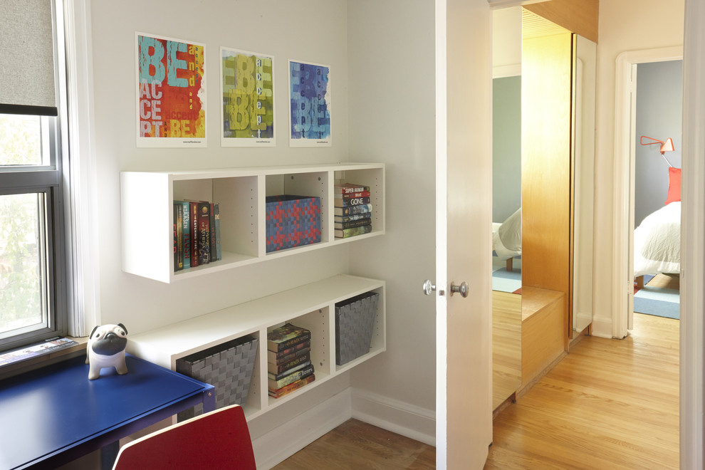 Cette photo montre une petite chambre d'enfant moderne avec un mur blanc et parquet clair.