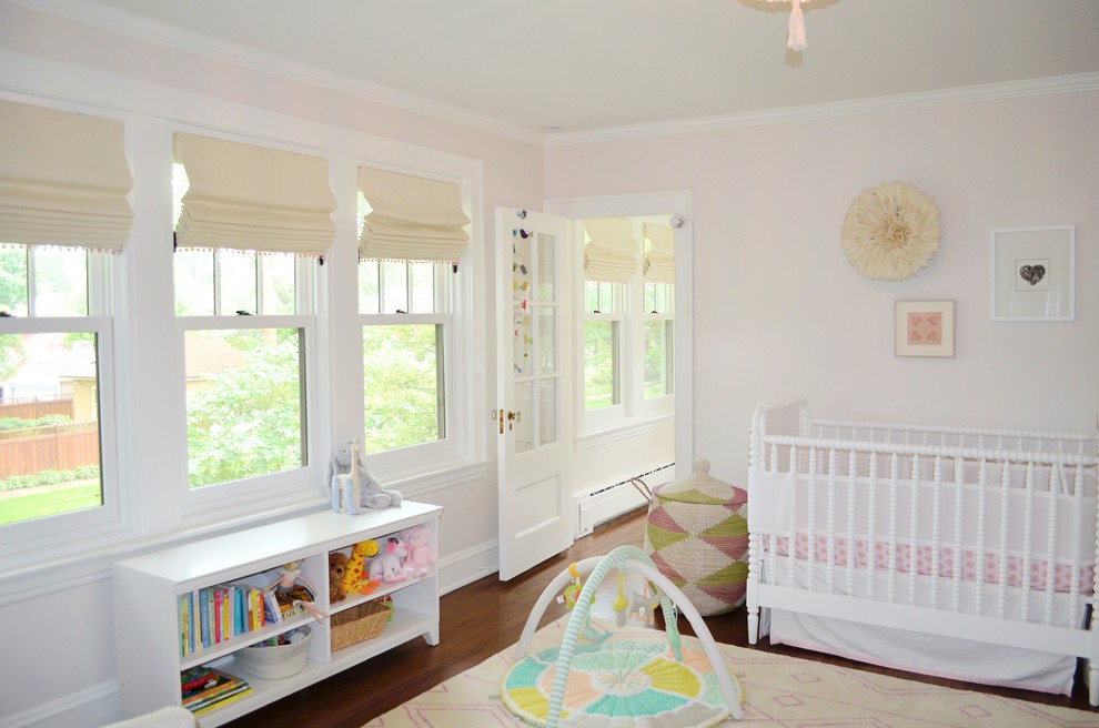 Foto de dormitorio infantil de 1 a 3 años clásico renovado grande con paredes rosas, suelo de madera en tonos medios y suelo marrón