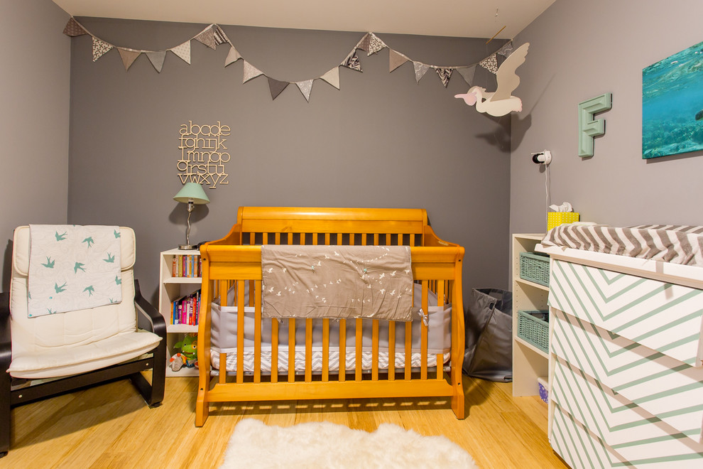 Mittelgroßes, Neutrales Modernes Babyzimmer mit grauer Wandfarbe und Bambusparkett in Calgary