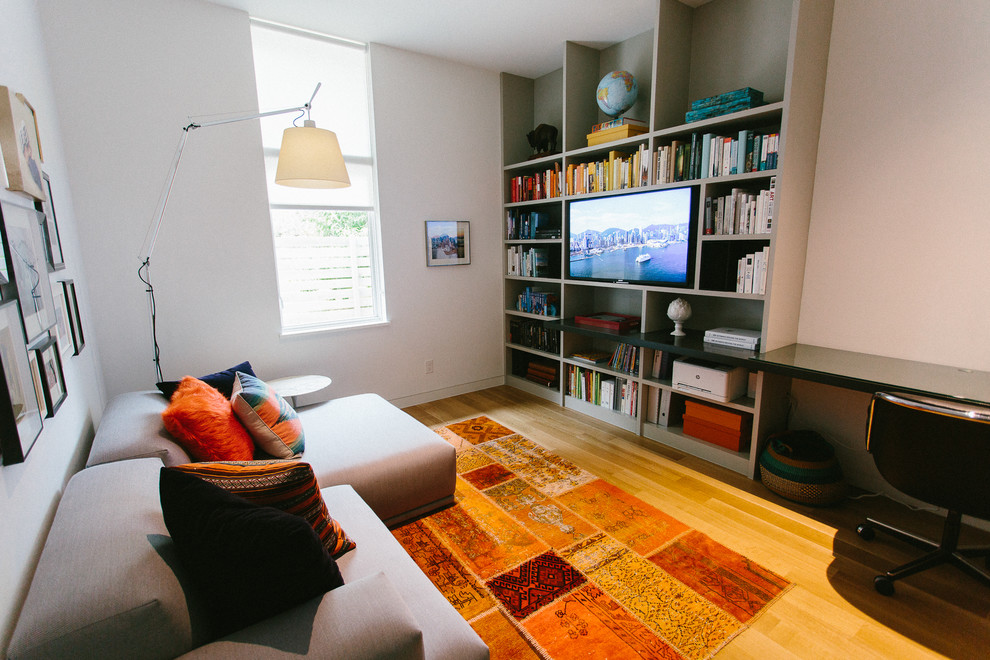 Idée de décoration pour une petite chambre neutre de 4 à 10 ans design avec un bureau, un mur blanc, parquet clair et un sol marron.