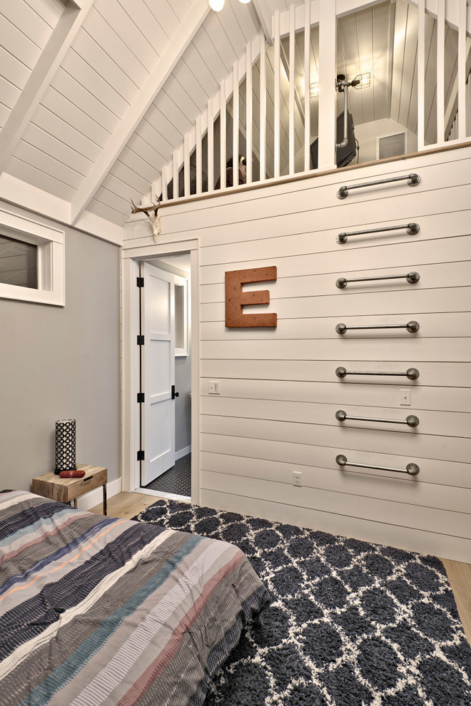 This is an example of a large country teen’s room for boys in Austin with grey walls, light hardwood flooring and brown floors.