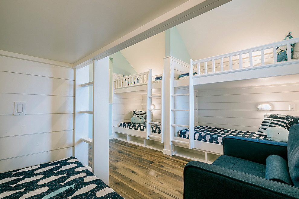 Immagine di una cameretta per bambini stile marino di medie dimensioni con pareti bianche, pavimento marrone e pavimento in legno massello medio