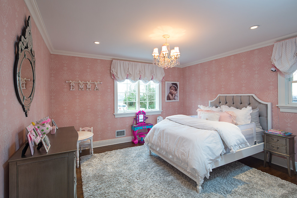 Exempel på ett klassiskt flickrum kombinerat med sovrum, med rosa väggar och mörkt trägolv