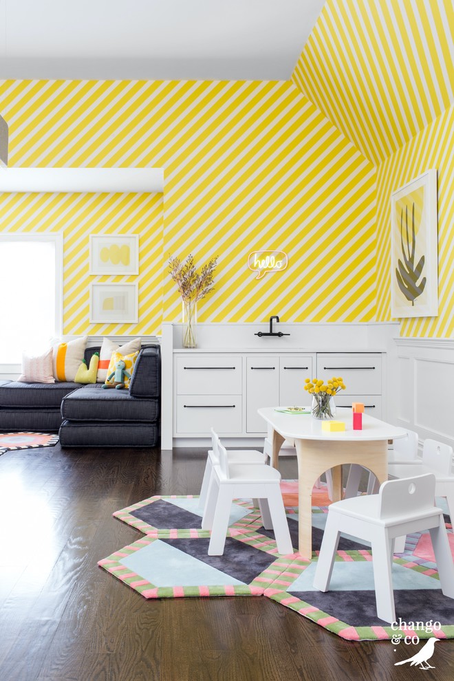 Inspiration för mycket stora klassiska könsneutrala småbarnsrum kombinerat med lekrum, med gula väggar, mörkt trägolv och brunt golv