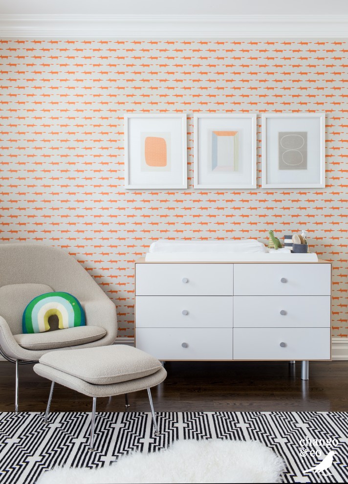 Huge transitional gender-neutral dark wood floor and brown floor kids' room photo in New York with orange walls