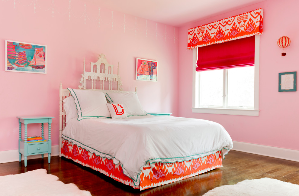 Klassisk inredning av ett barnrum kombinerat med sovrum, med rosa väggar och mellanmörkt trägolv