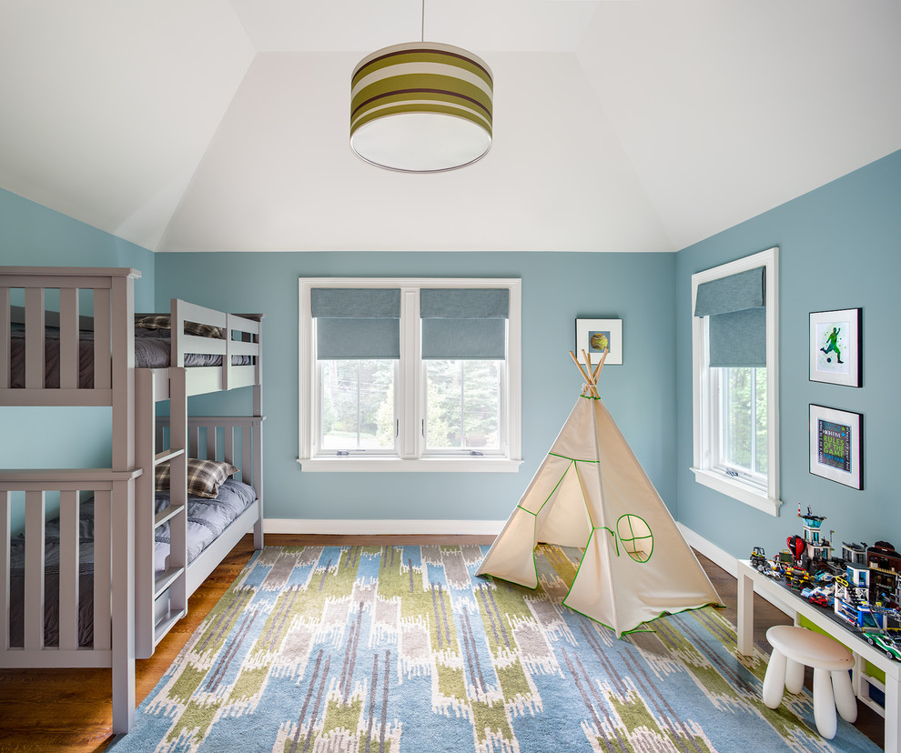 Réalisation d'une chambre d'enfant tradition de taille moyenne avec un mur bleu, un sol en bois brun, un sol marron et un lit superposé.