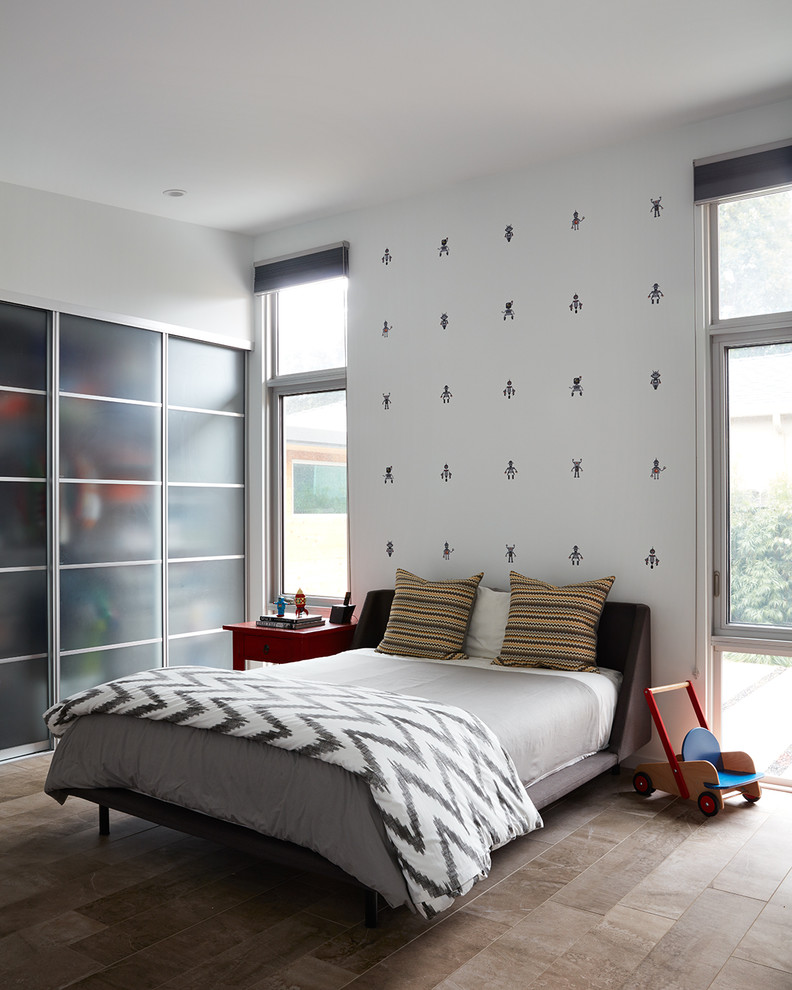 This is an example of a contemporary children’s room for boys in San Francisco with white walls and brown floors.