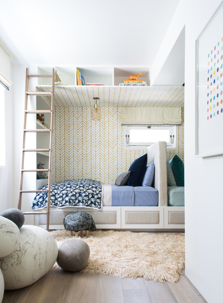 Inspiration för klassiska könsneutrala barnrum kombinerat med sovrum, med vita väggar och ljust trägolv