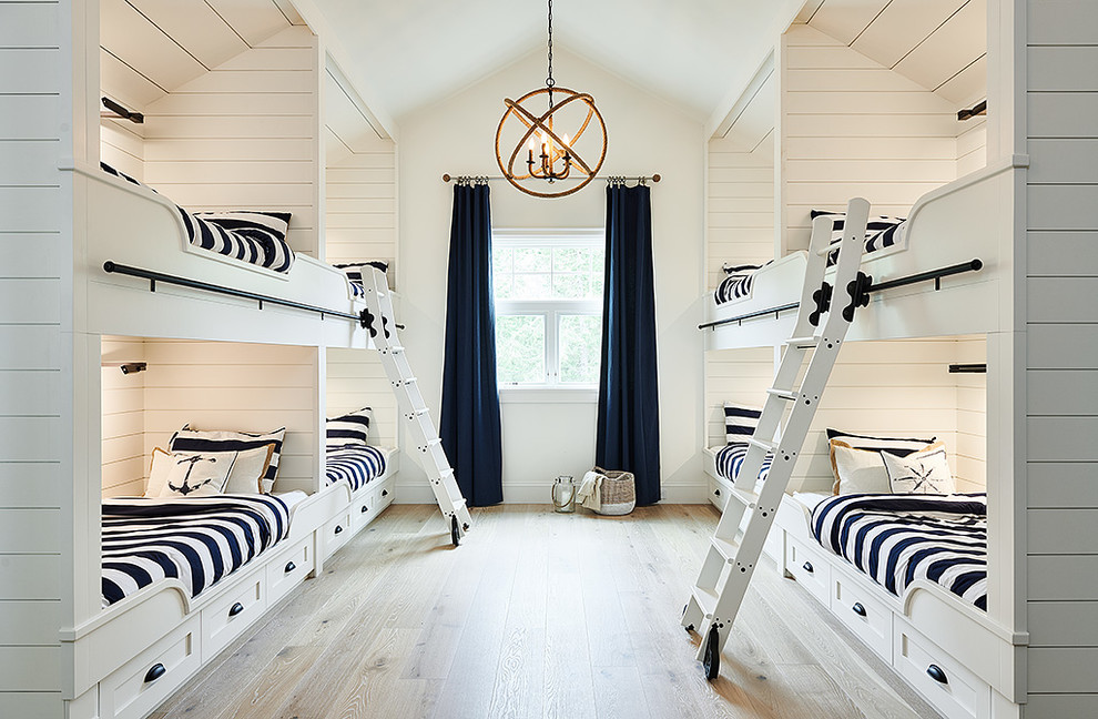 Esempio di una cameretta per bambini stile marino di medie dimensioni con pareti bianche, parquet chiaro e pavimento beige