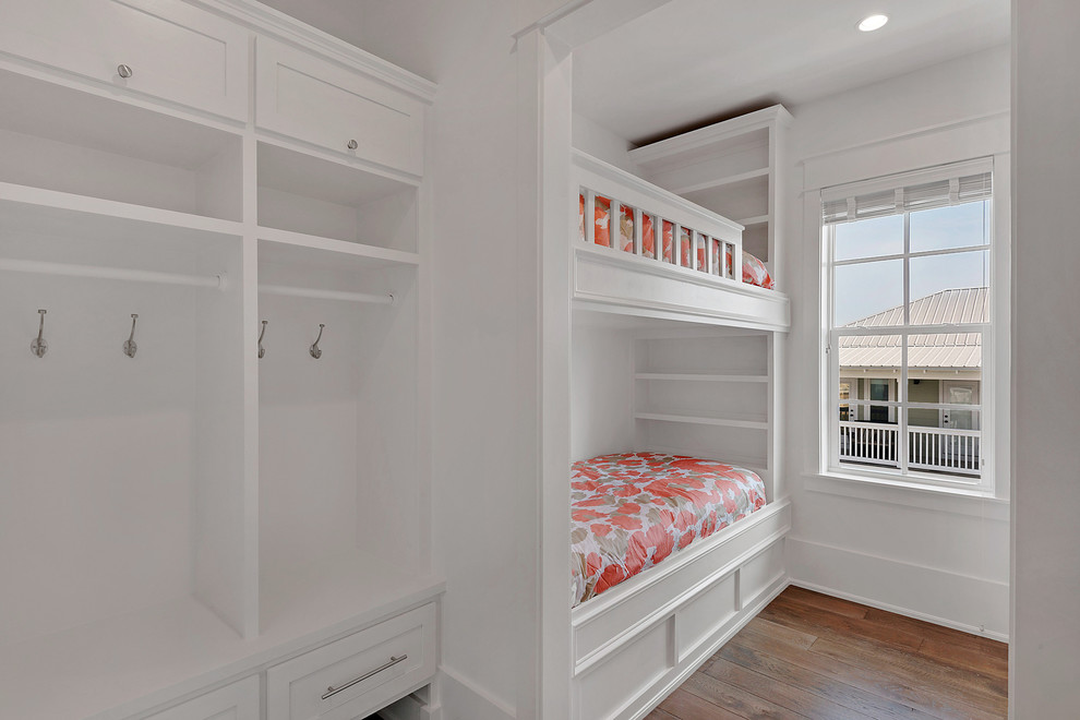 Immagine di una cameretta per bambini da 4 a 10 anni country di medie dimensioni con pareti bianche, parquet chiaro e pavimento marrone