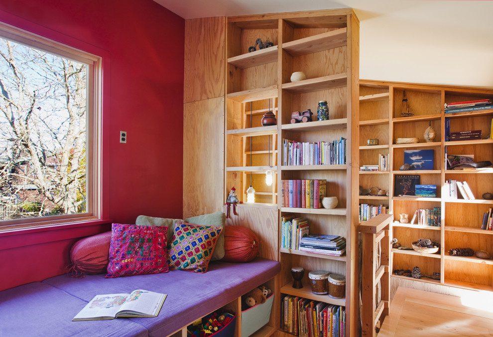 Inredning av ett modernt mellanstort barnrum kombinerat med skrivbord, med ljust trägolv och flerfärgade väggar