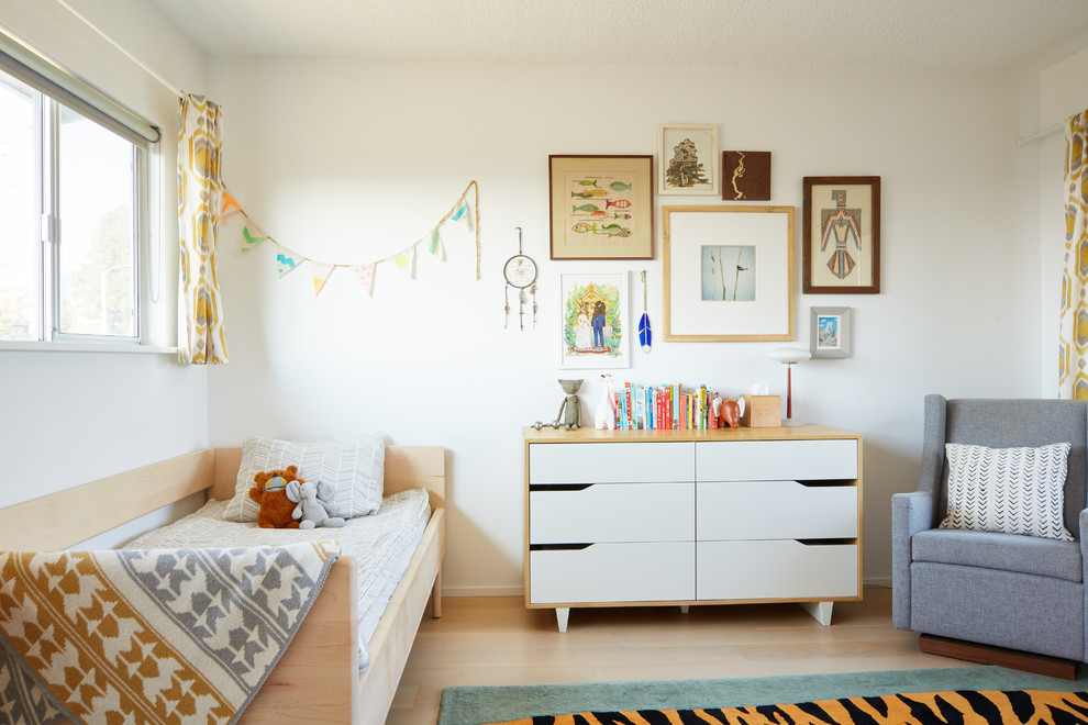 Inspiration för 50 tals könsneutrala småbarnsrum kombinerat med sovrum, med vita väggar, ljust trägolv och beiget golv