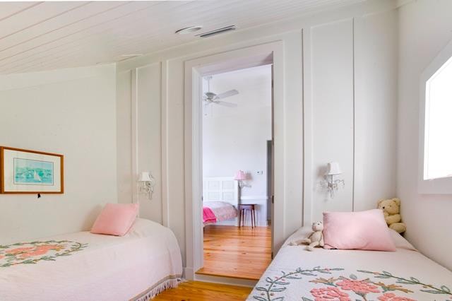 Inspiration for a mid-sized coastal girl medium tone wood floor kids' room remodel in Tampa with white walls