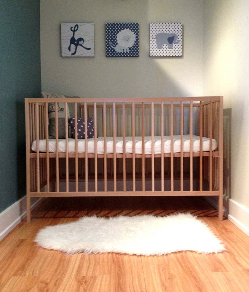 Diseño de habitación de bebé neutra actual de tamaño medio con paredes verdes