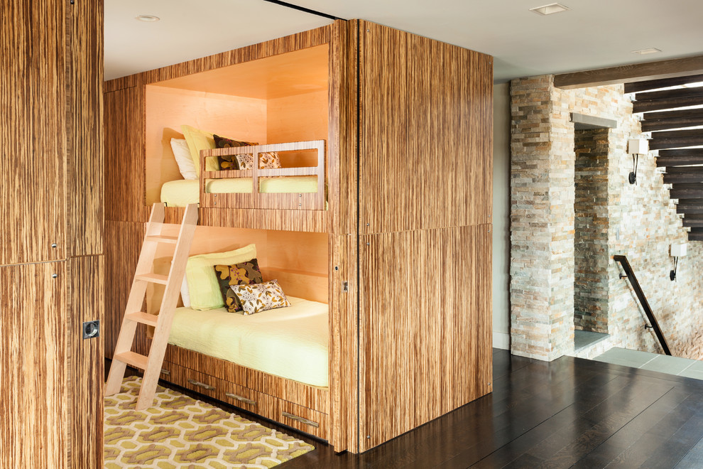 Idée de décoration pour une grande chambre d'enfant de 4 à 10 ans design avec parquet foncé, un mur beige, un sol marron et un lit superposé.
