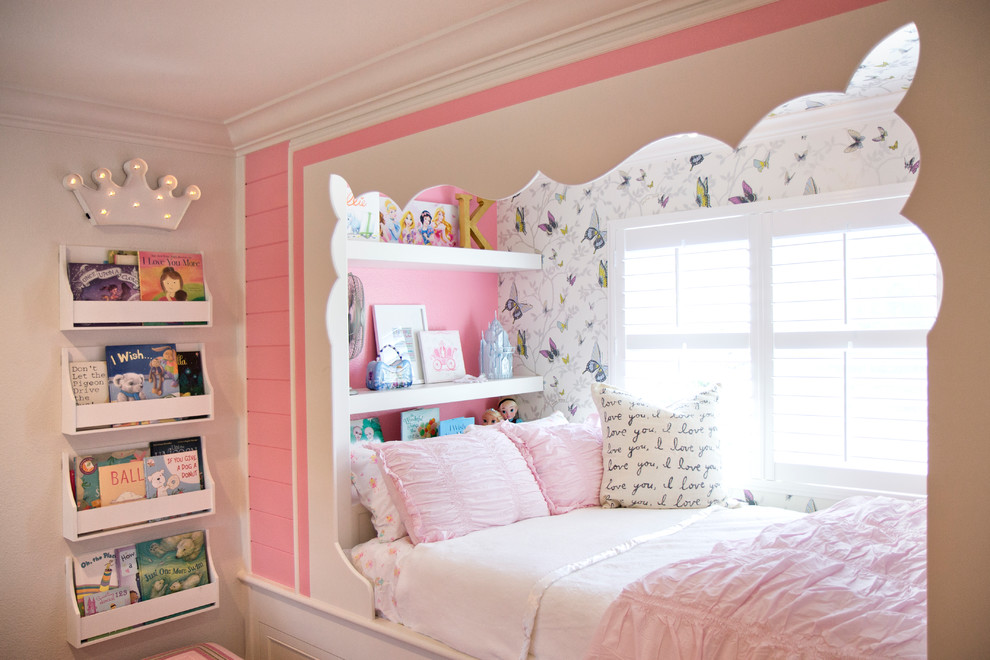 This is an example of a medium sized classic children’s room for girls in San Diego with pink walls and medium hardwood flooring.