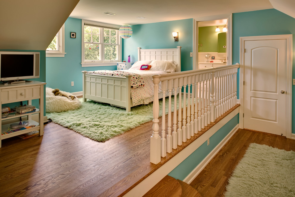 Esempio di una cameretta per bambini da 4 a 10 anni tradizionale con pareti blu e pavimento in legno massello medio