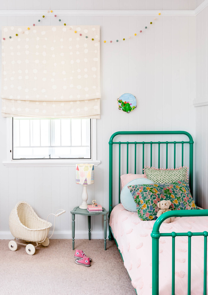 This is an example of a medium sized scandinavian toddler’s room for girls in Brisbane with white walls, carpet and beige floors.