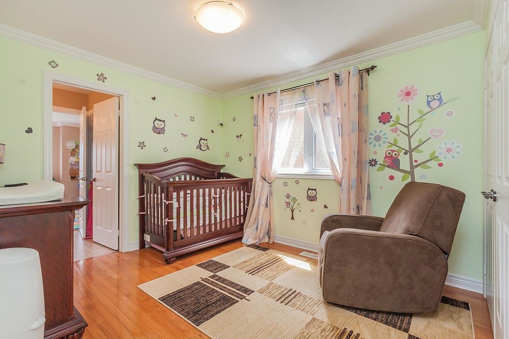 Mittelgroßes Klassisches Babyzimmer mit grüner Wandfarbe und hellem Holzboden in Toronto