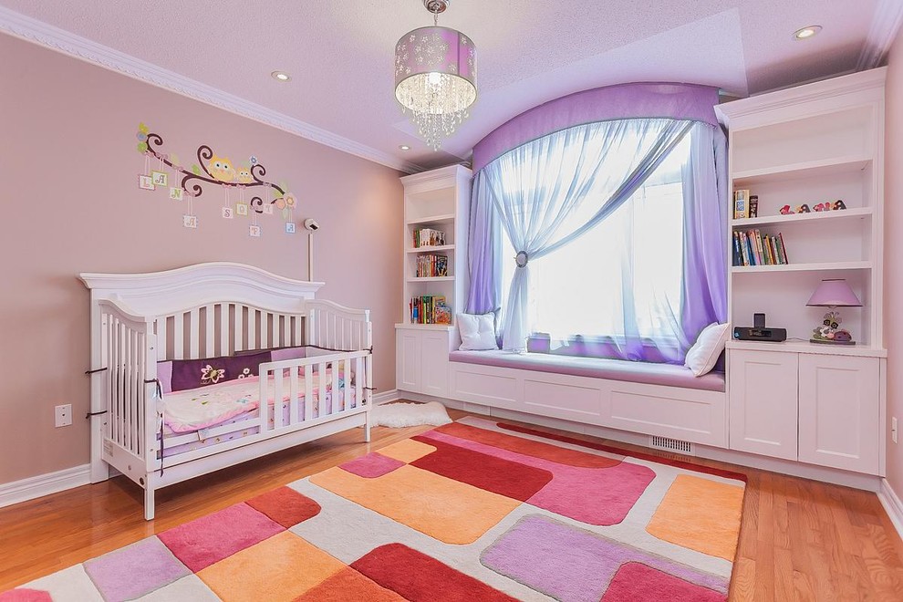 Bild på ett stort vintage barnrum kombinerat med sovrum, med rosa väggar och ljust trägolv