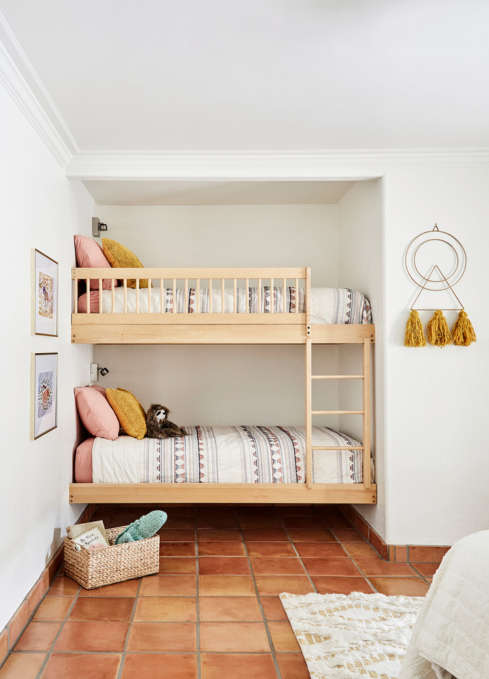 サクラメントにあるサンタフェスタイルのおしゃれな子供部屋 (白い壁、テラコッタタイルの床、児童向け、オレンジの床、二段ベッド) の写真