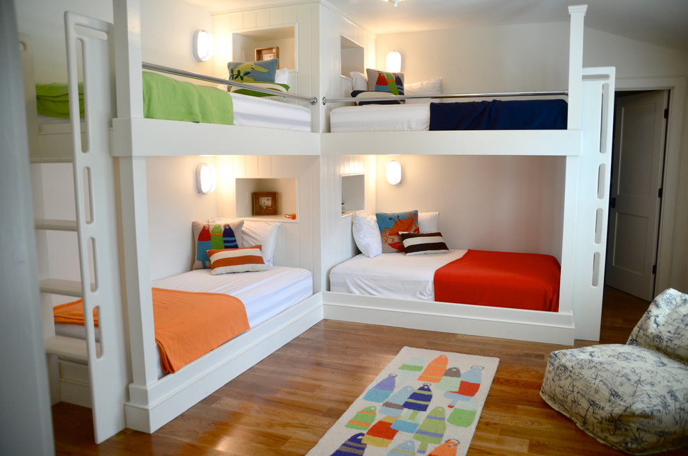 Example of a beach style gender-neutral medium tone wood floor kids' room design in Boston with white walls