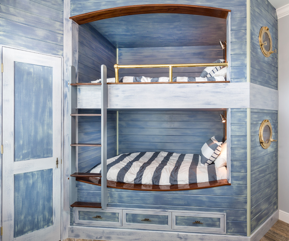 Idee per una piccola cameretta per bambini stile marinaro con pareti blu e pavimento in legno massello medio