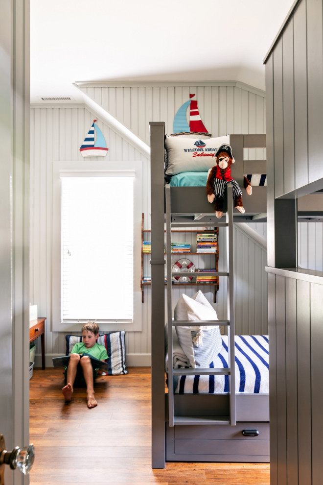 Cette image montre une chambre d'enfant de 4 à 10 ans marine de taille moyenne avec un mur gris, un sol en bois brun et un sol marron.
