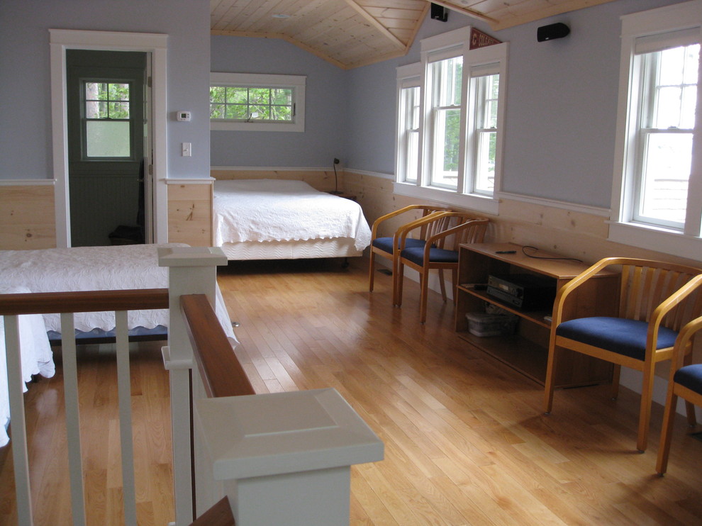 Idee per una piccola cameretta da letto american style con pareti blu e pavimento in legno massello medio