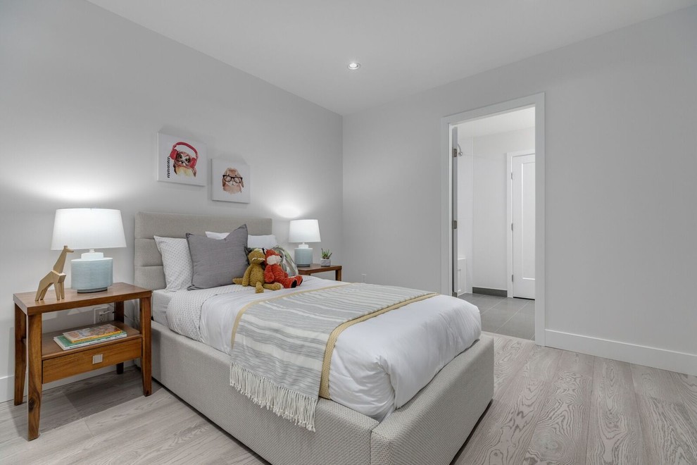 Modelo de dormitorio infantil de 4 a 10 años moderno grande con paredes blancas, suelo de madera clara y suelo beige