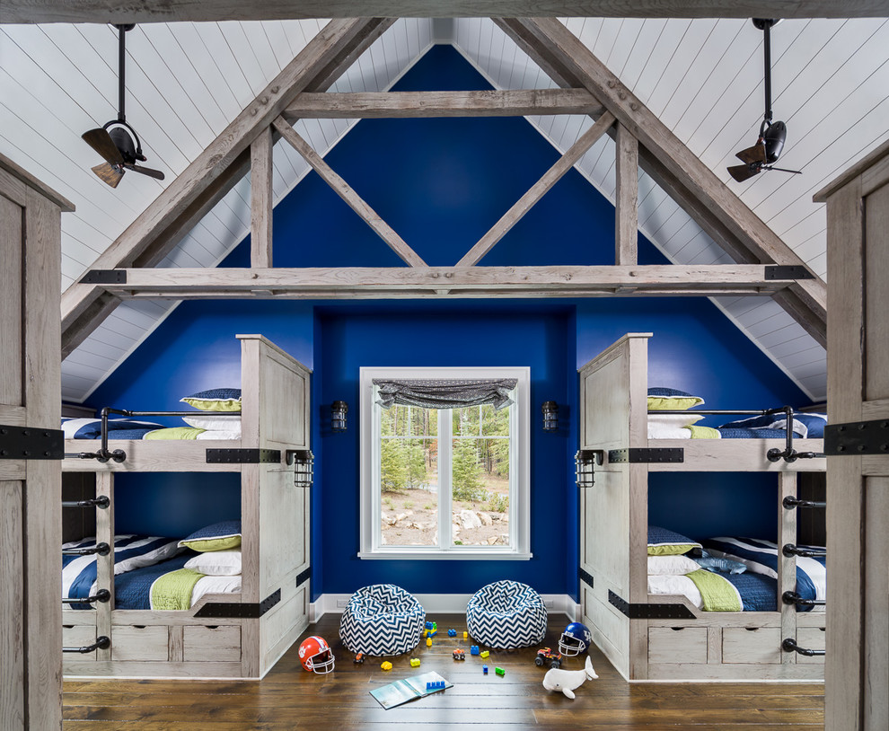 Inspiration för stora lantliga könsneutrala barnrum kombinerat med sovrum, med blå väggar och mörkt trägolv