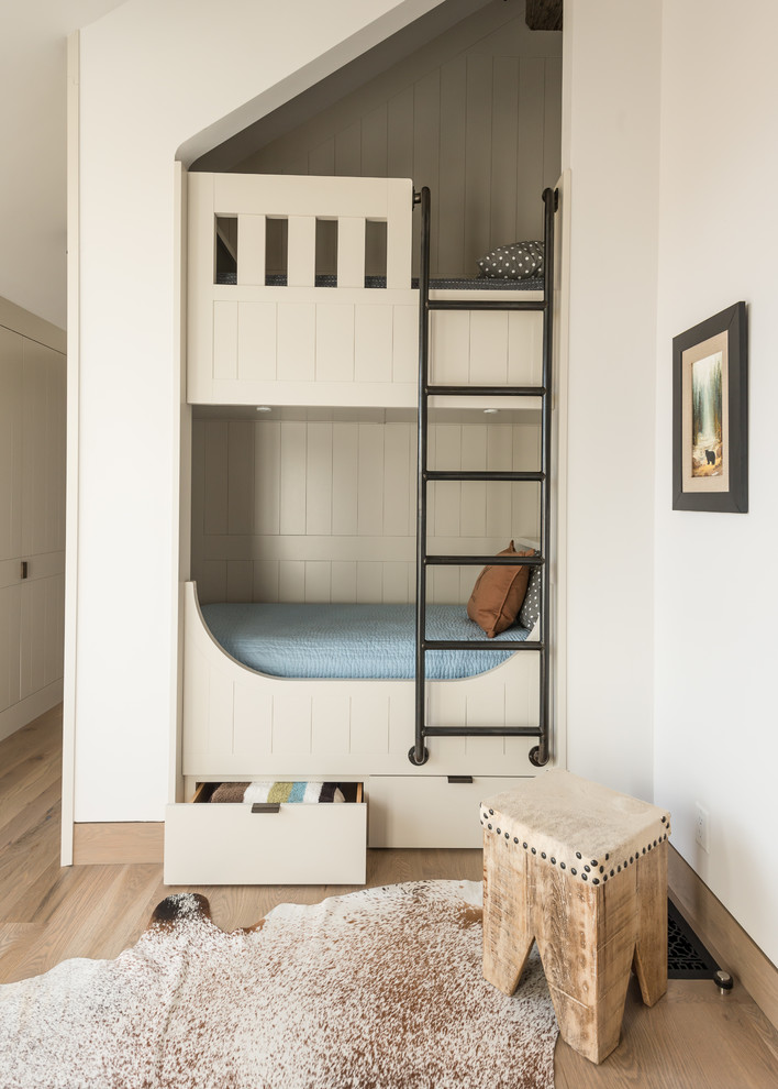 Diseño de dormitorio infantil tradicional renovado con paredes blancas, suelo de madera clara y suelo beige