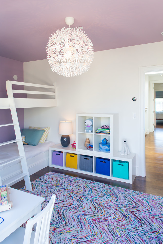 Cette image montre une chambre d'enfant de 1 à 3 ans design avec un sol en bois brun et un mur multicolore.
