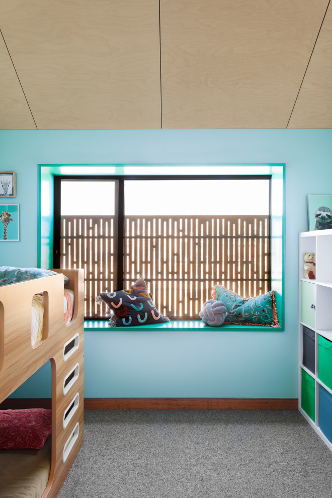 Cette photo montre une chambre d'enfant scandinave avec un mur bleu, moquette, un sol gris et un plafond en lambris de bois.