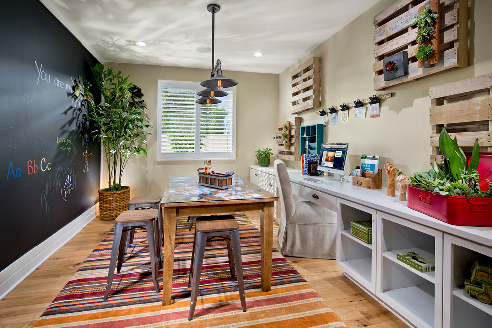 Exemple d'une chambre neutre méditerranéenne avec un bureau, un sol en bois brun et un mur multicolore.
