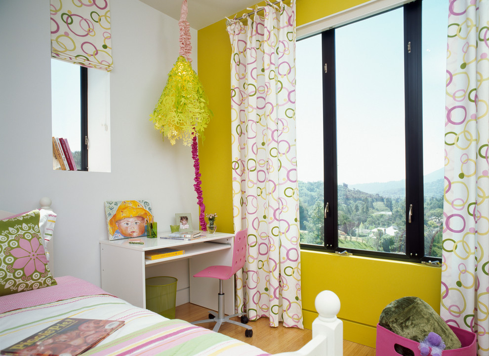 Exempel på ett modernt flickrum kombinerat med sovrum, med ljust trägolv och flerfärgade väggar