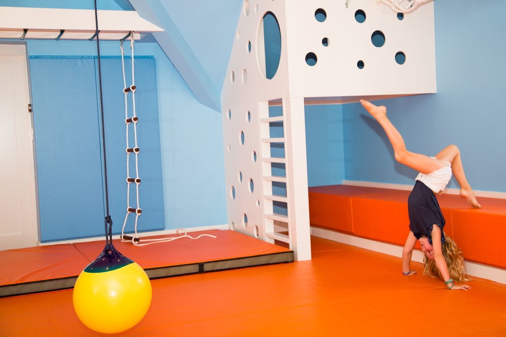 На фото: нейтральная детская с игровой среднего размера в современном стиле с синими стенами и оранжевым полом для ребенка от 4 до 10 лет