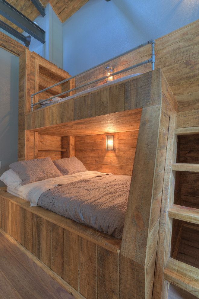 Lantlig inredning av ett mellanstort könsneutralt tonårsrum kombinerat med sovrum, med blå väggar och mellanmörkt trägolv