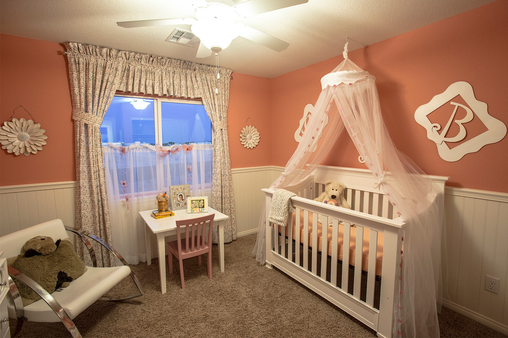 Esempio di una piccola cameretta per neonati neutra con pareti arancioni e moquette