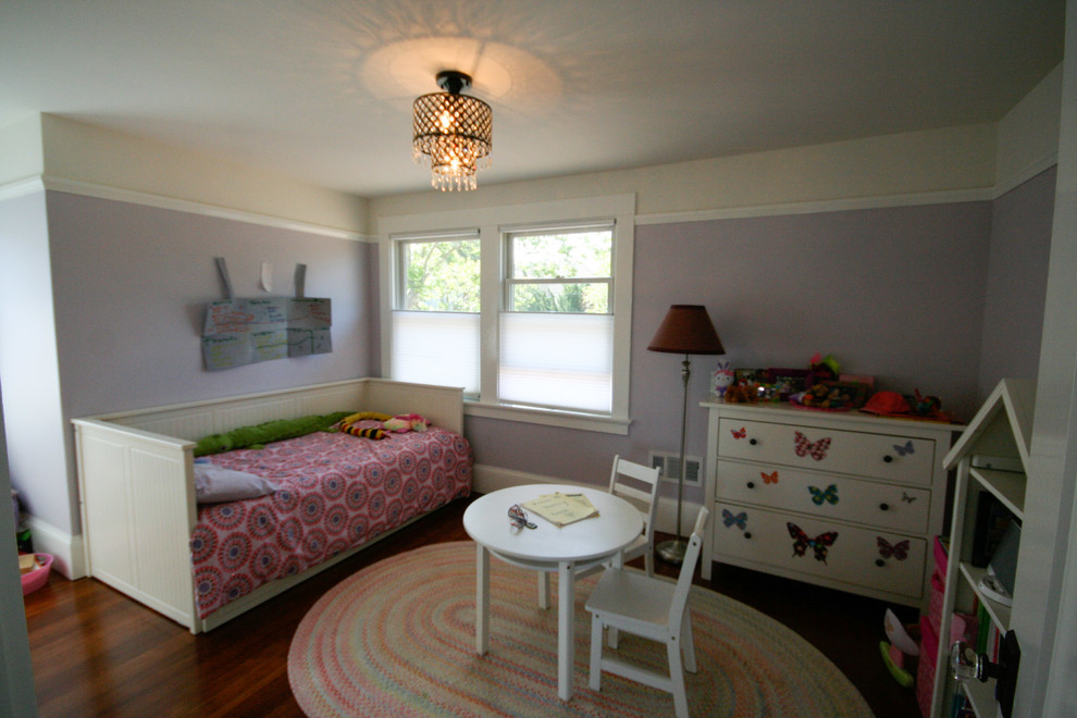 Photo of a medium sized classic children’s room for girls in San Francisco with purple walls and dark hardwood flooring.