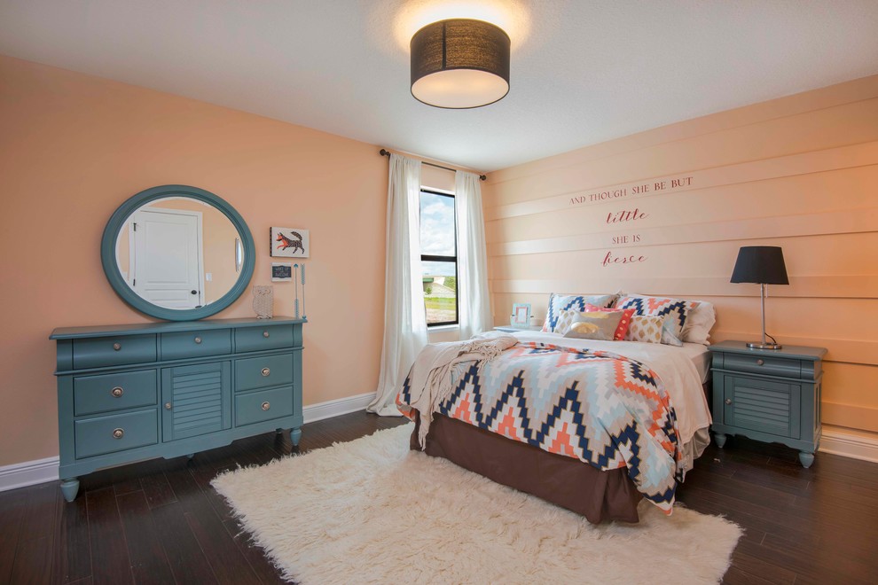 Inredning av ett eklektiskt mellanstort barnrum kombinerat med sovrum, med rosa väggar och mörkt trägolv